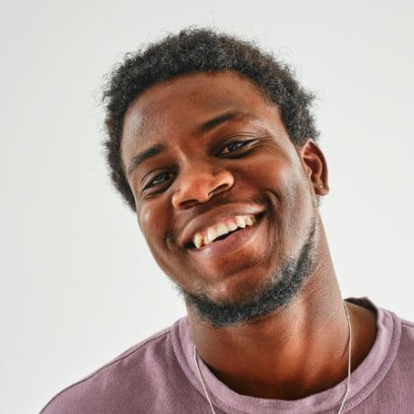 Man wearing a faded tshirt smiling - Image by Andrej Lisakov